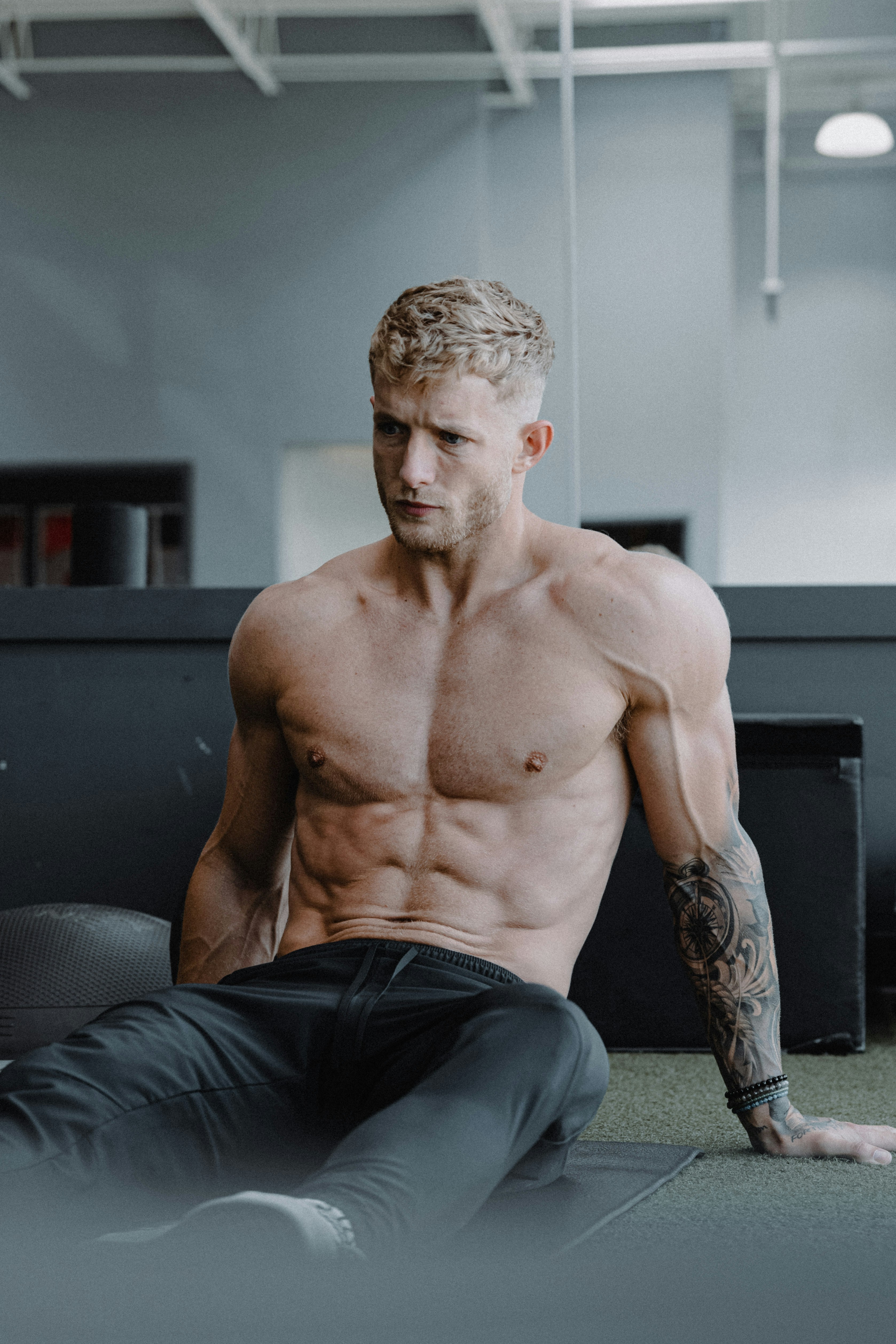 Un homme torse nu est assis par terre photo – Photo Pilates Gratuite ...