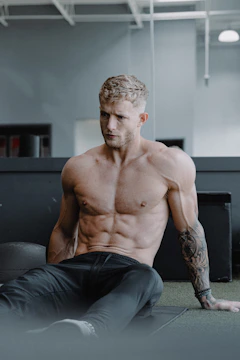 Close-up of a male athlete using recovery equipment in a minimalist training space.