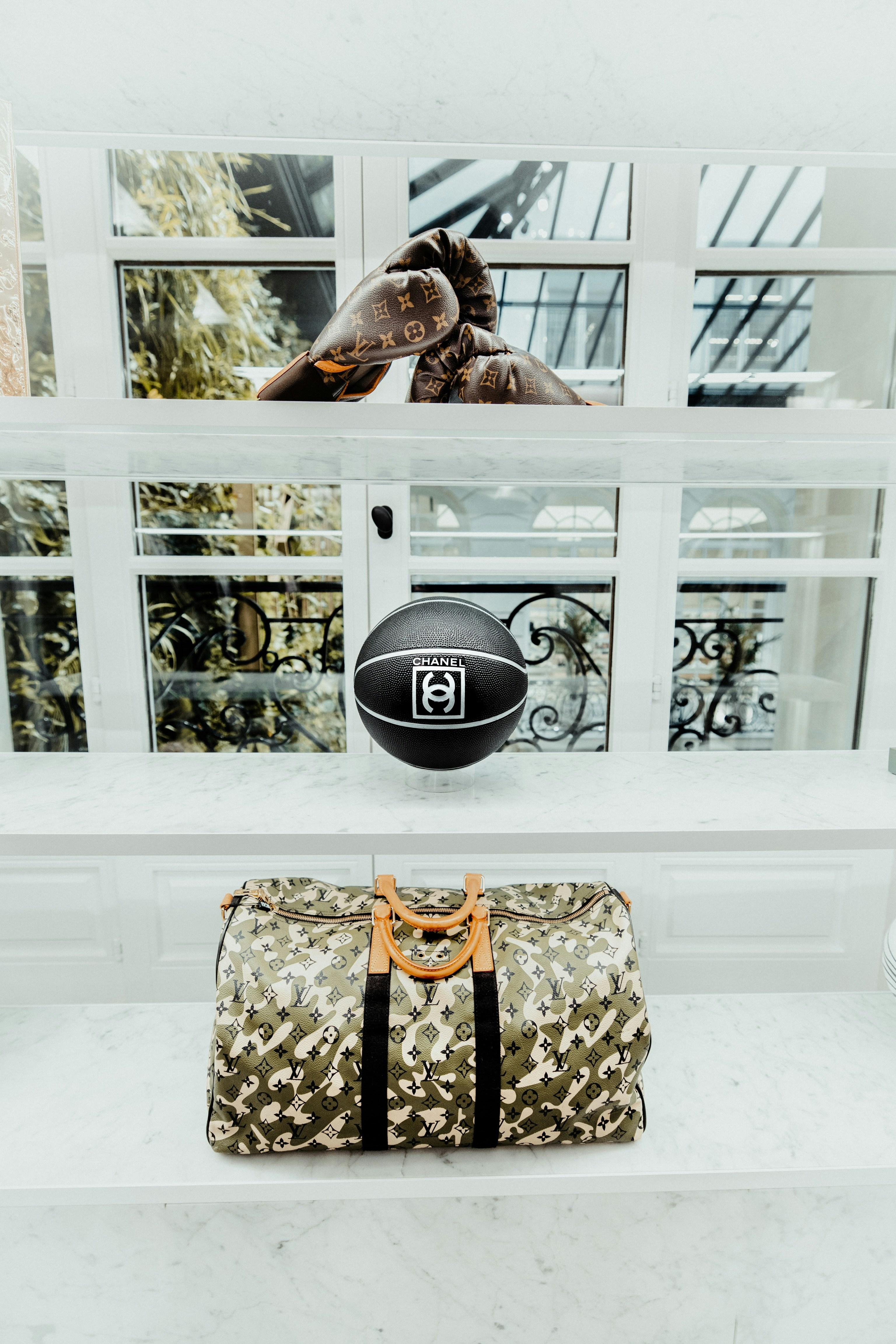 Designer sporting goods and bags displayed on marble shelves.