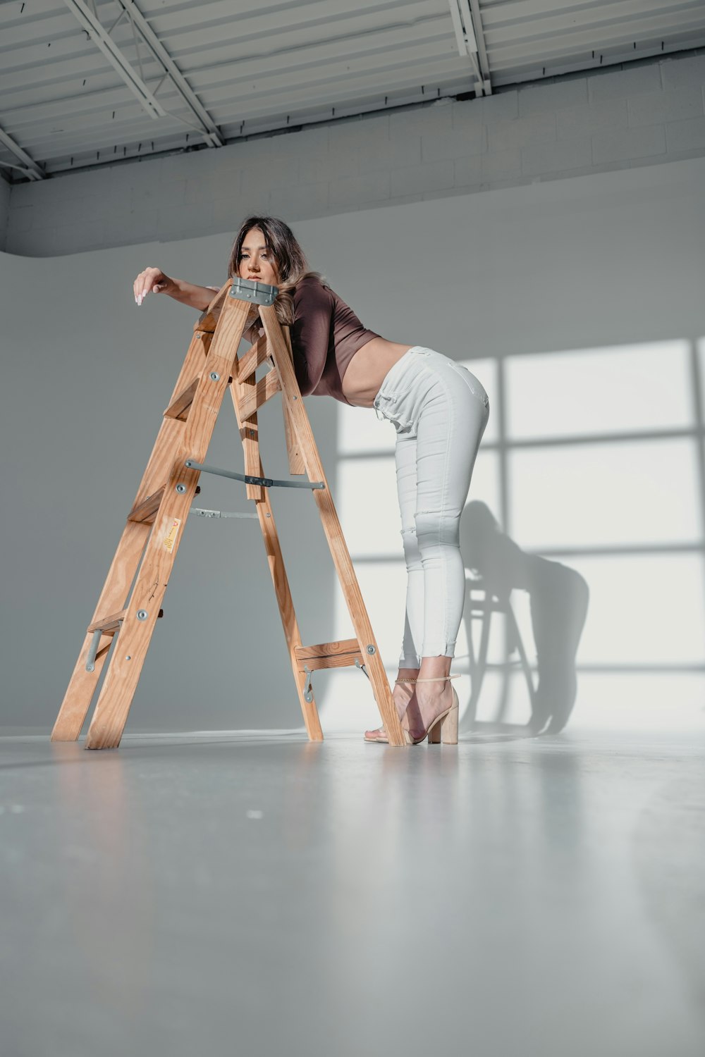 a woman standing on a ladder in a room
