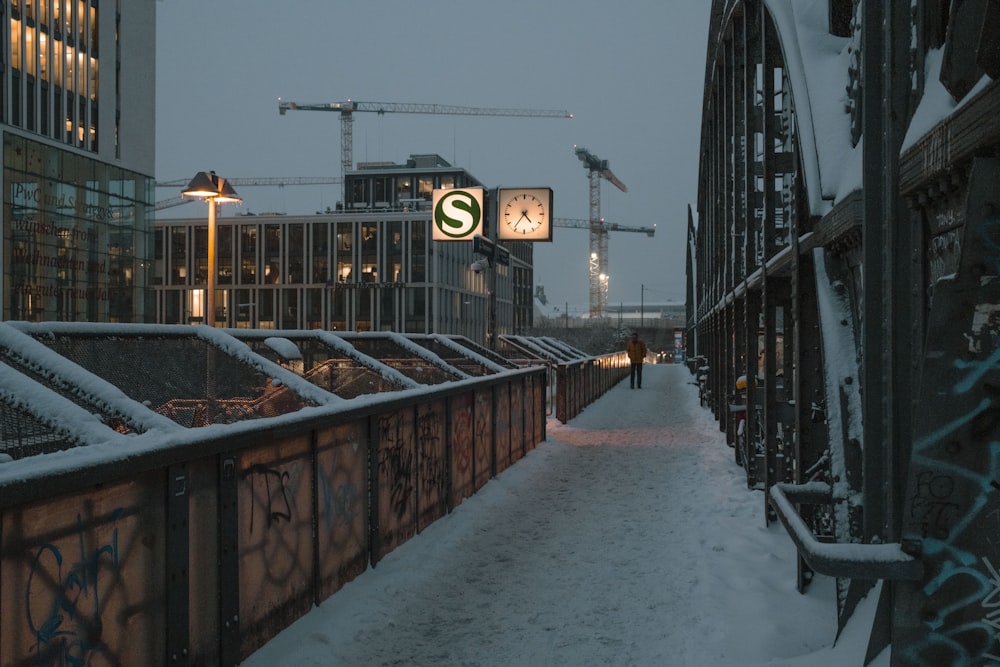 a person walking on a bridge in the snow