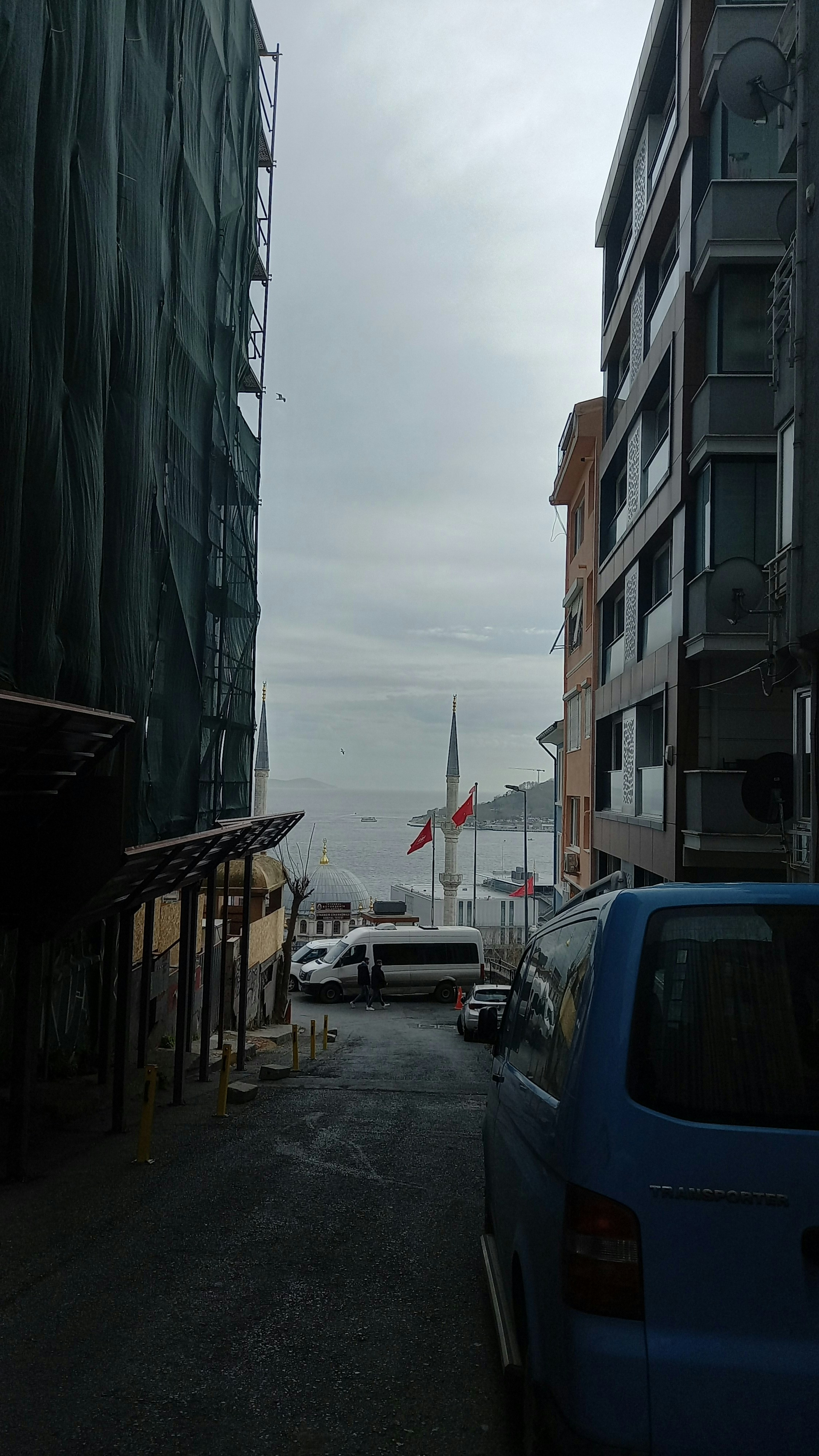 Coches aparcados al costado de una carretera junto a edificios altos