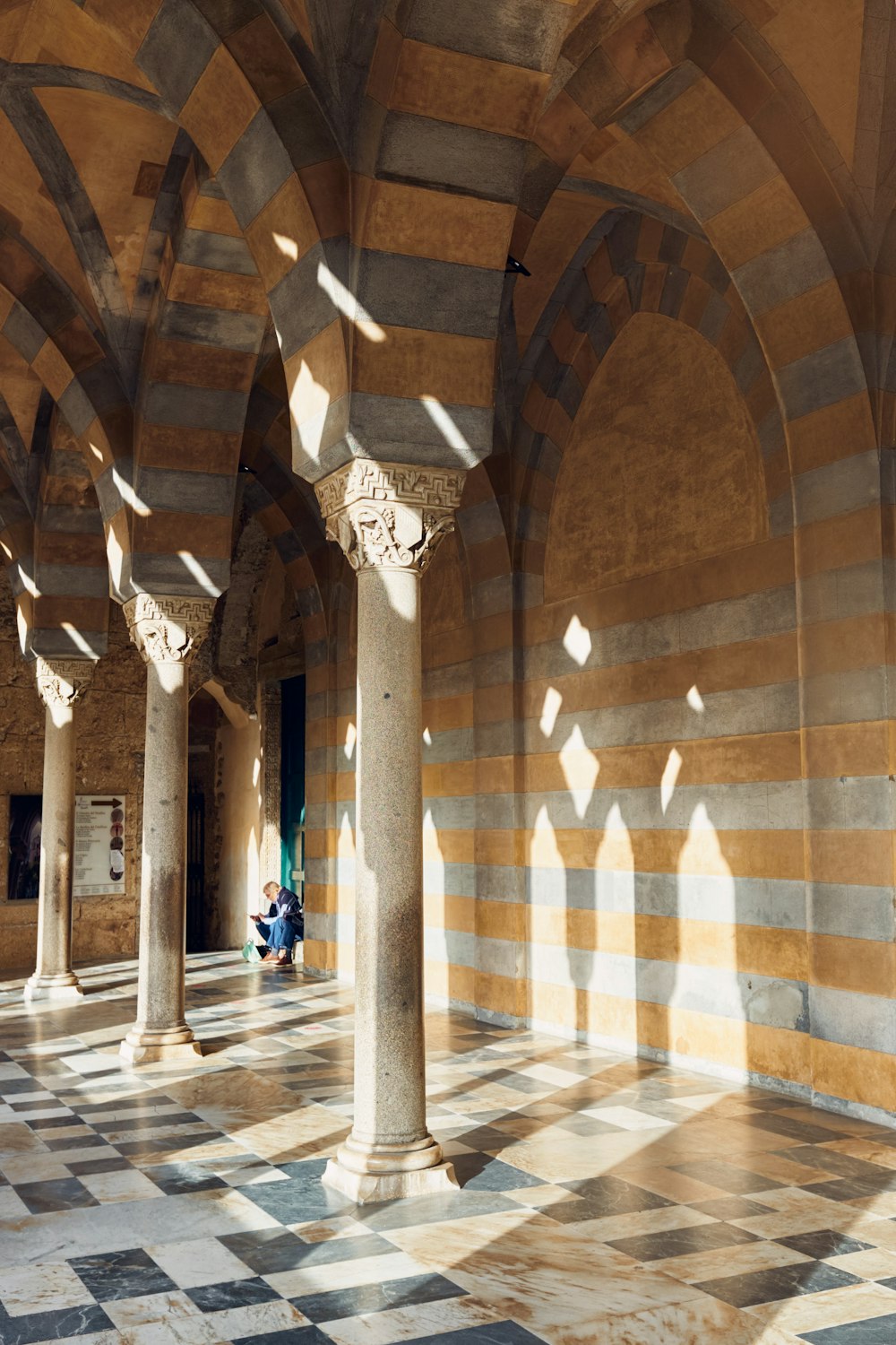 a person sitting on a bench in a large building