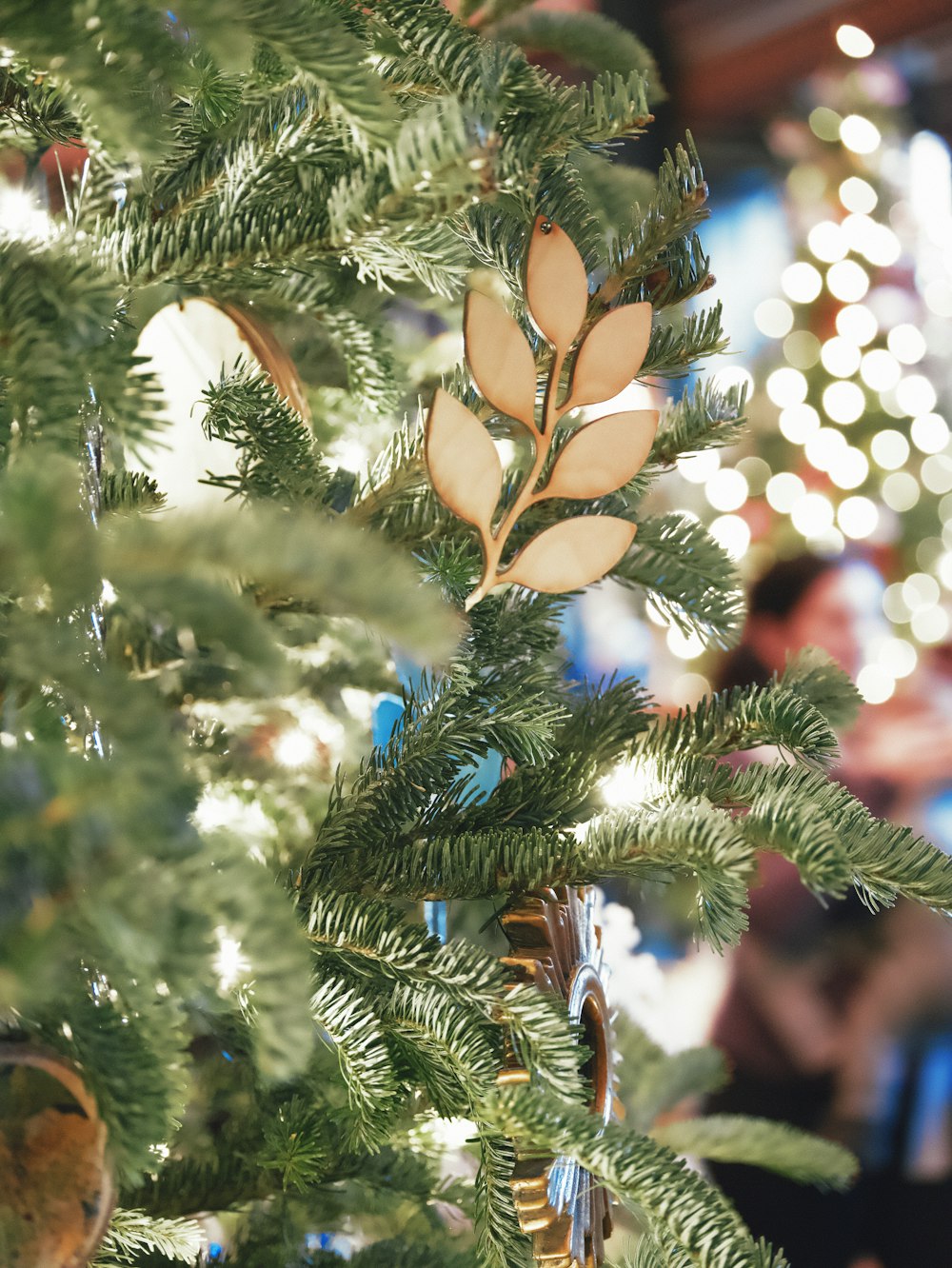 a close up of a christmas tree with lights in the background