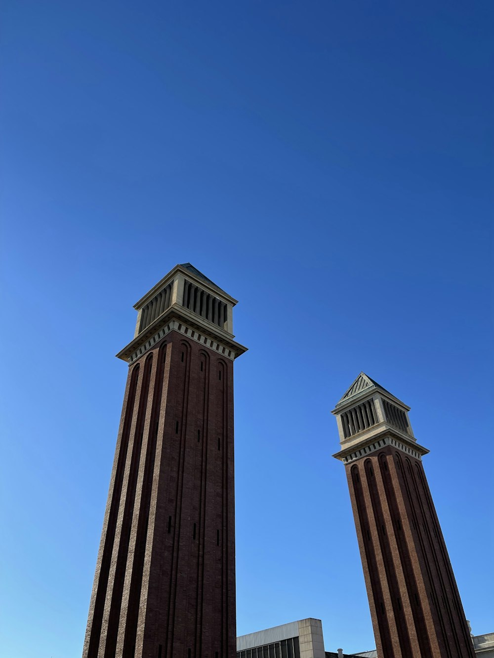 two tall brick buildings with a clock on each of them