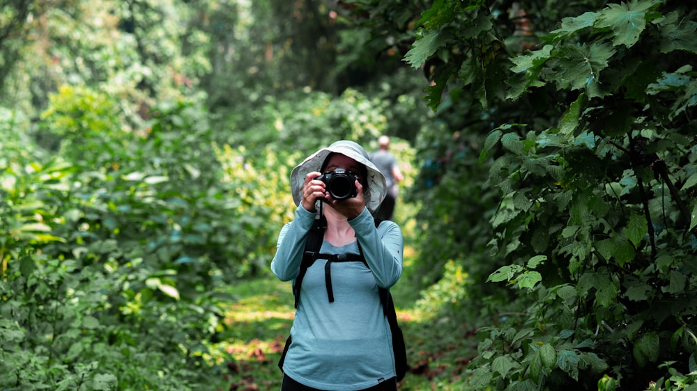 a woman taking a picture of herself in the woods