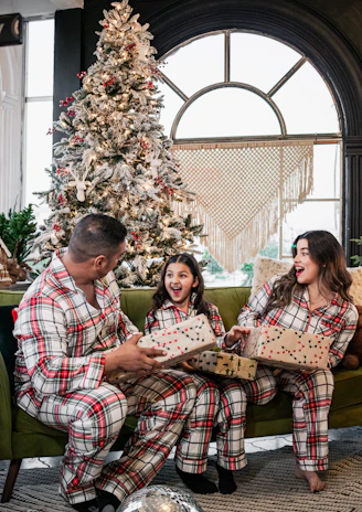 A joyful family moment with matching comfy outfits in a sleek, dark-themed room.