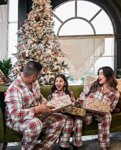 A joyful family moment with matching comfy outfits in a sleek, dark-themed room.
