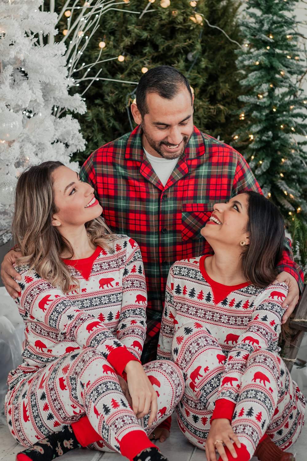 a man and a woman wearing matching christmas pajamas