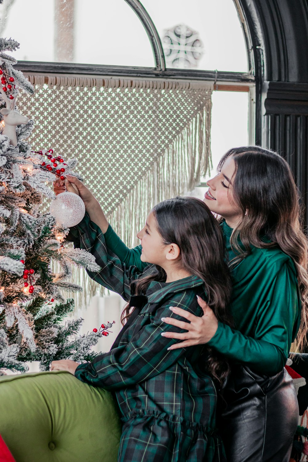 Una madre y su hija decorando un árbol de Navidad