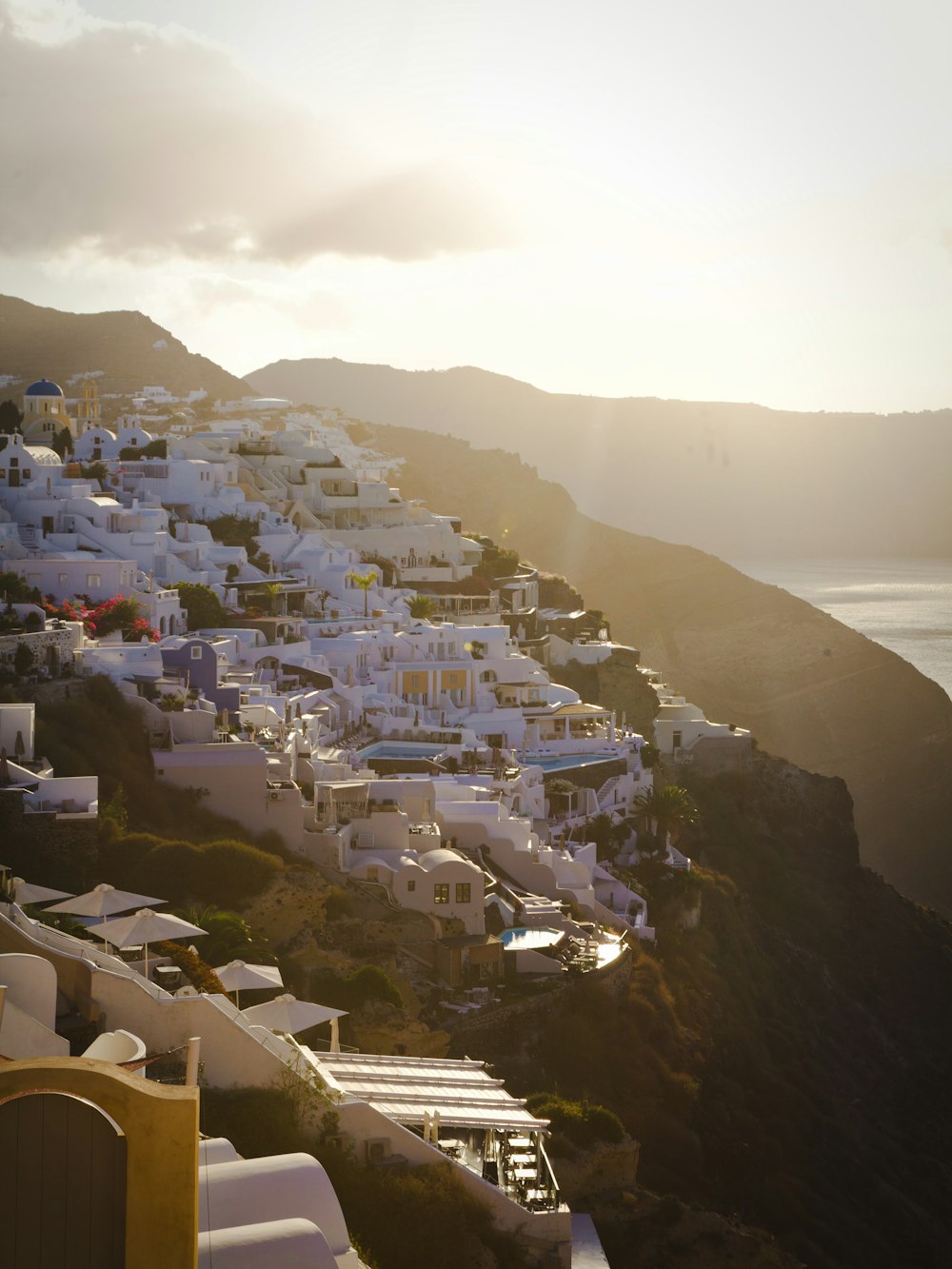 a view of a village on a cliff overlooking the ocean