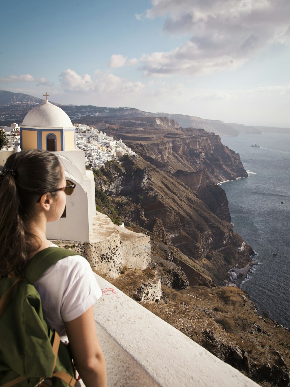 a woman with a backpack looking at the ocean