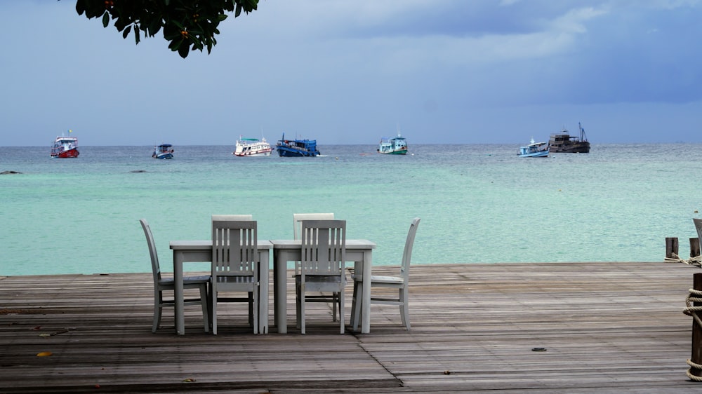 a group of chairs sitting on top of a wooden dock