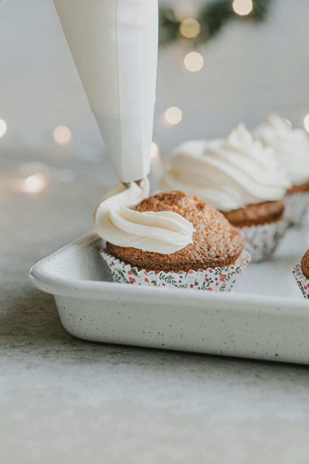 un cupcake siendo glaseado con glaseado en un plato