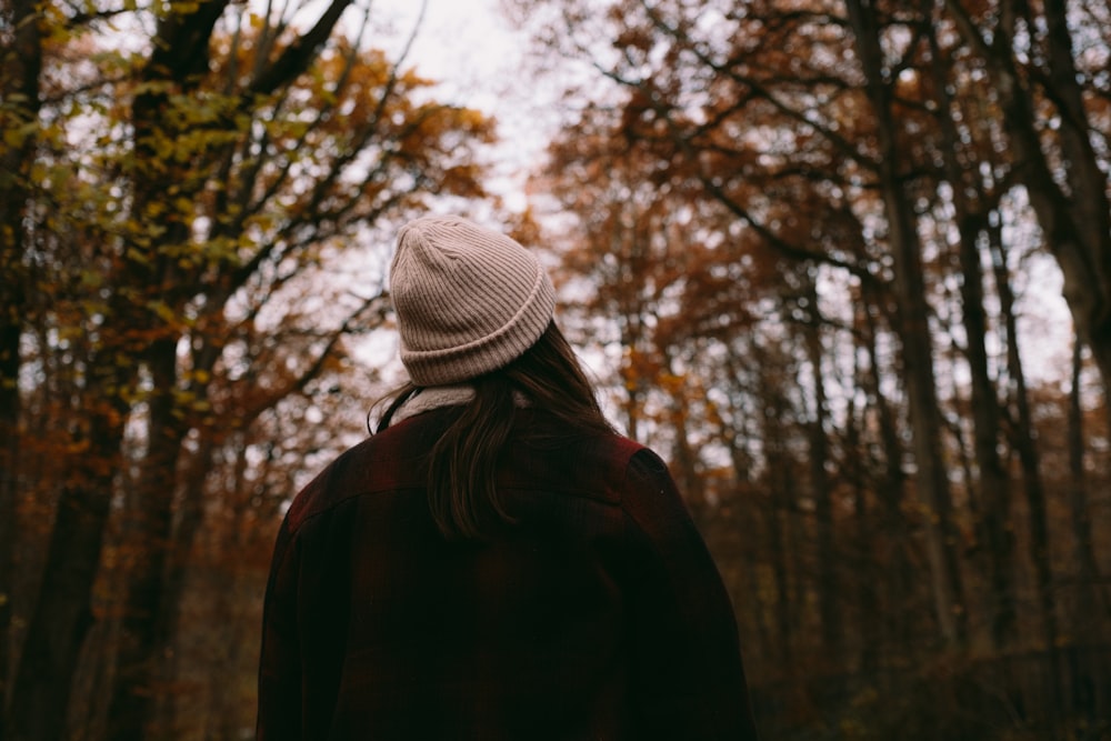 a person standing in a forest with trees in the background