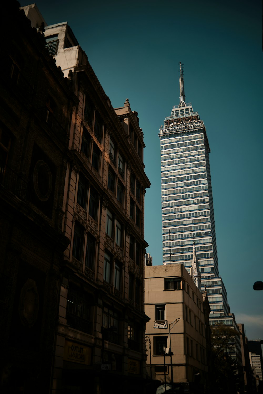 a tall building towering over a city filled with tall buildings