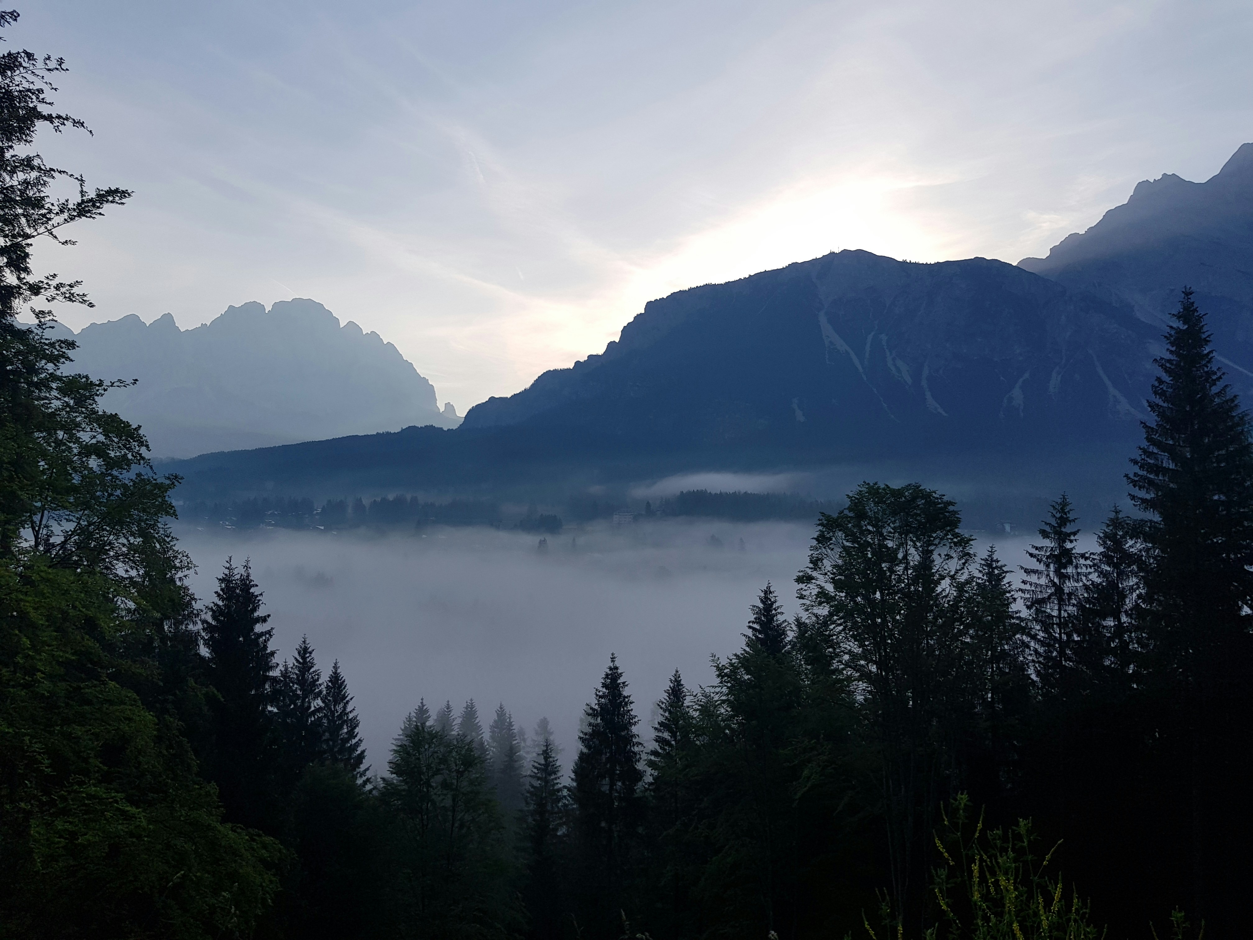 a view of a mountain range with trees in the foreground