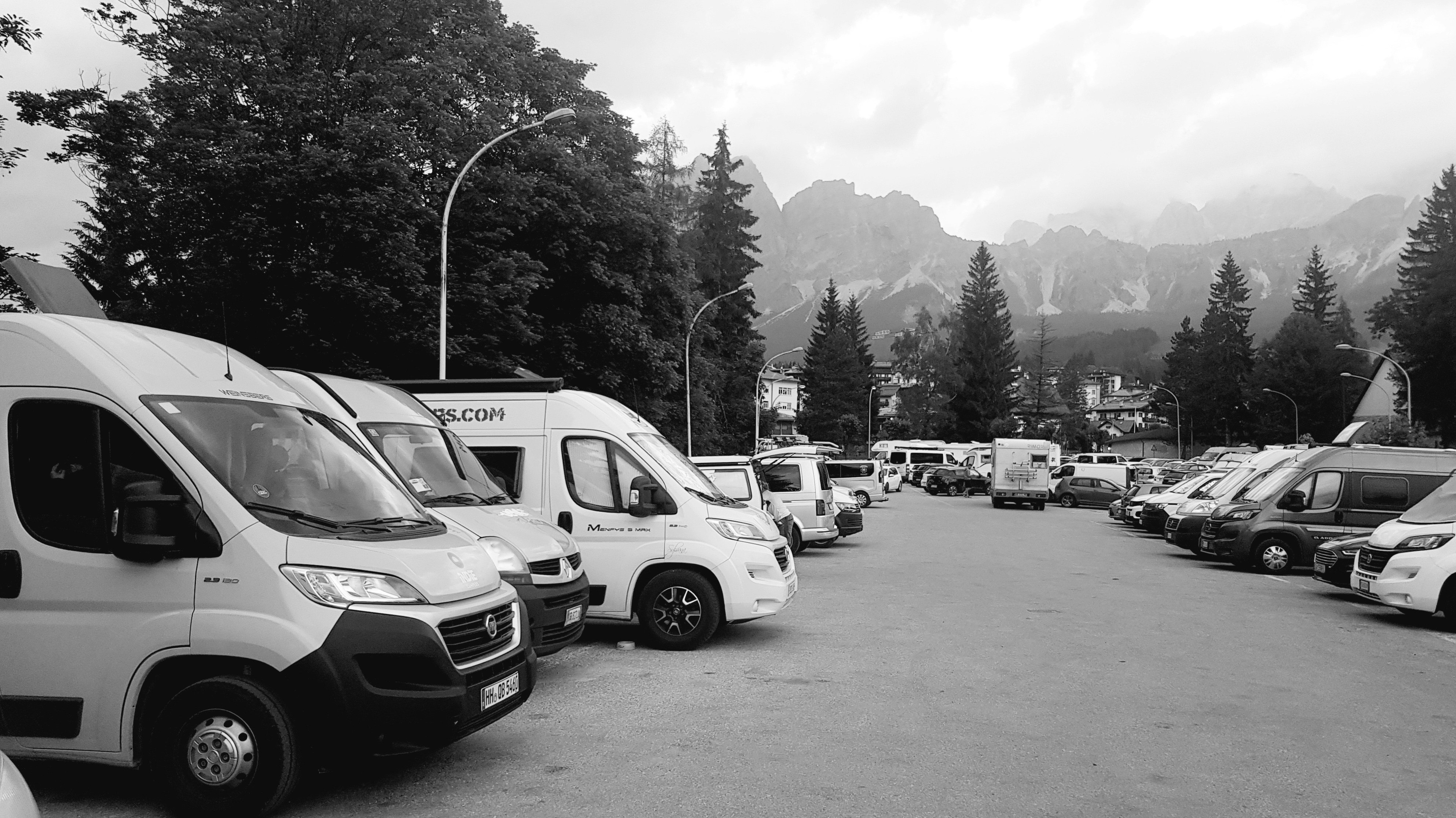 a black and white photo of a parking lot full of vans