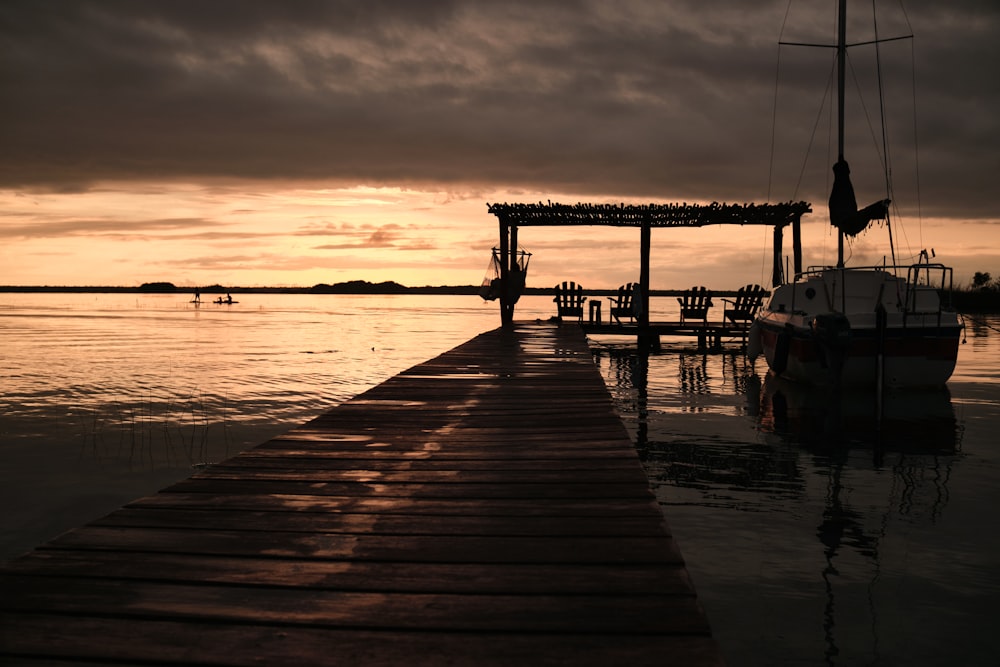 a boat is docked at a pier at sunset