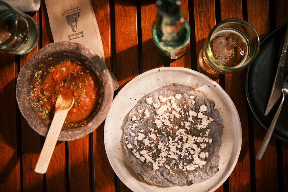 a wooden table topped with a bowl of food