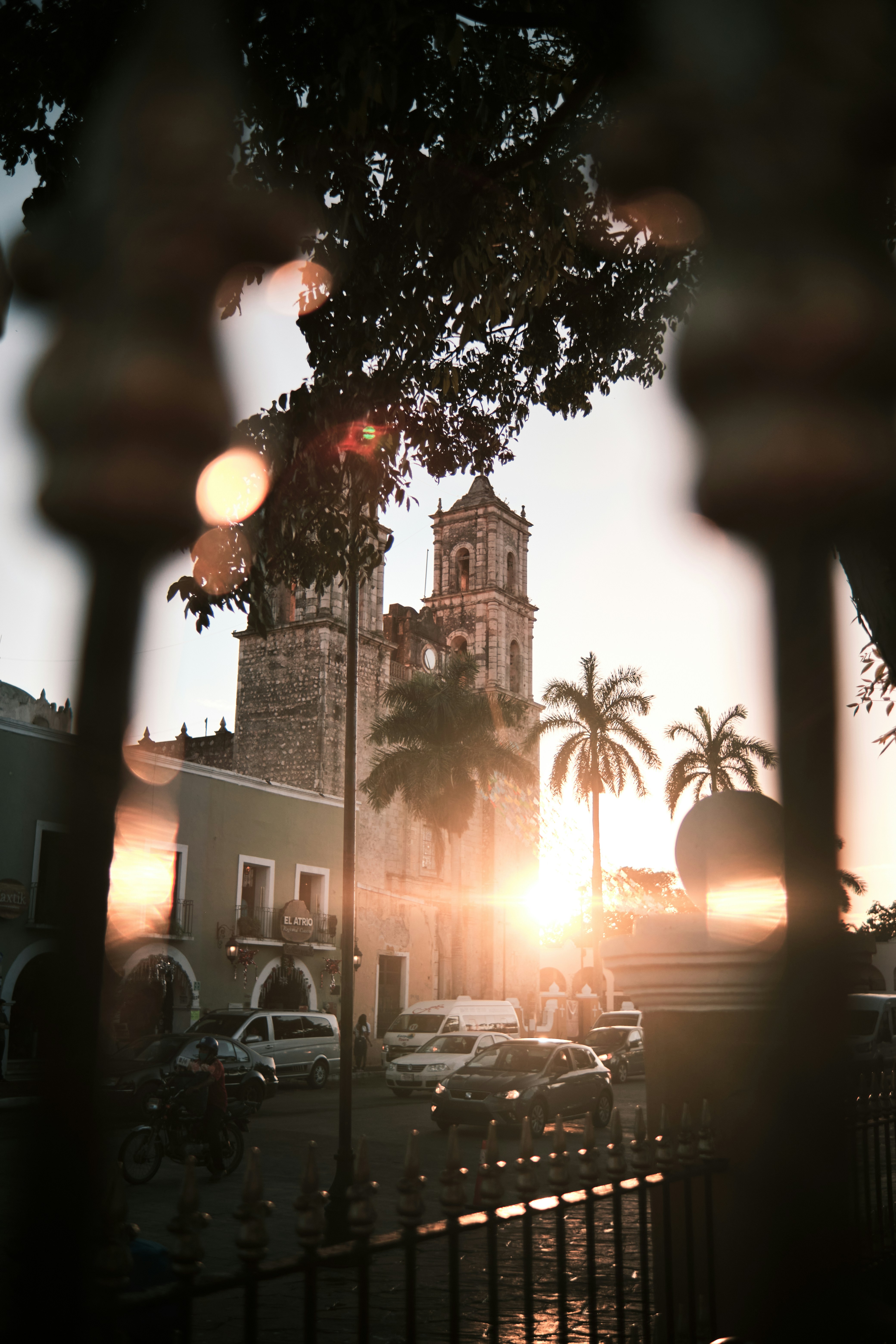 o sol está se pondo atrás de um edifício alto