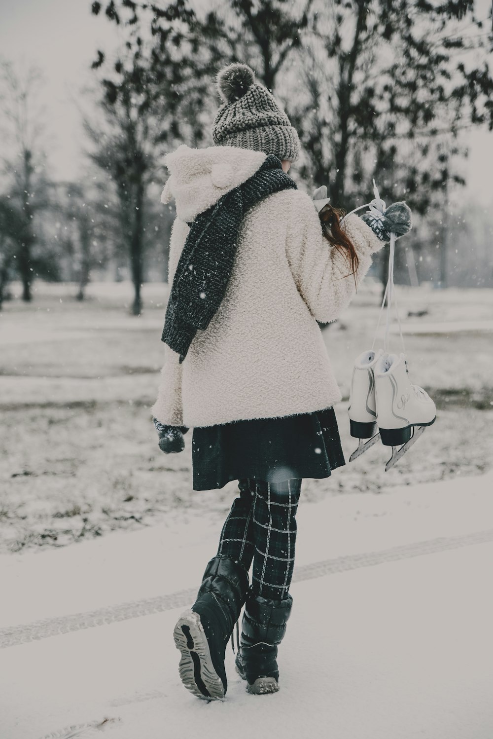 a woman walking down a snow covered street