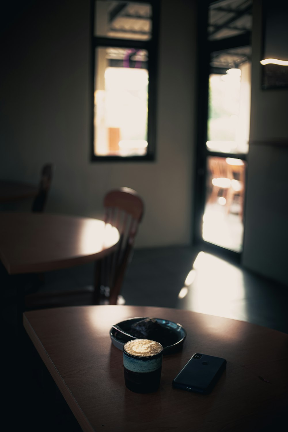 uma xícara de café e um celular em uma mesa