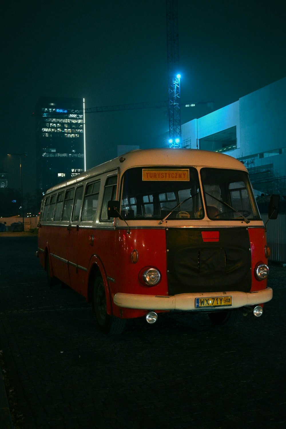 a red and white bus parked in a parking lot