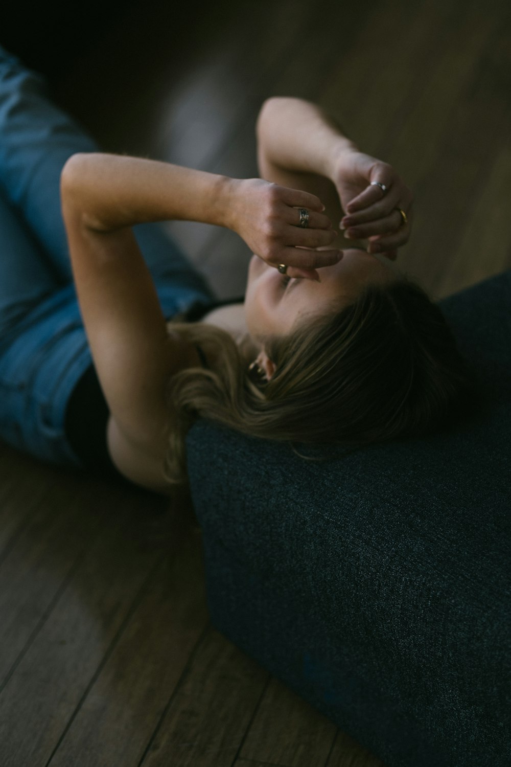 a woman laying on the floor with her hands on her head