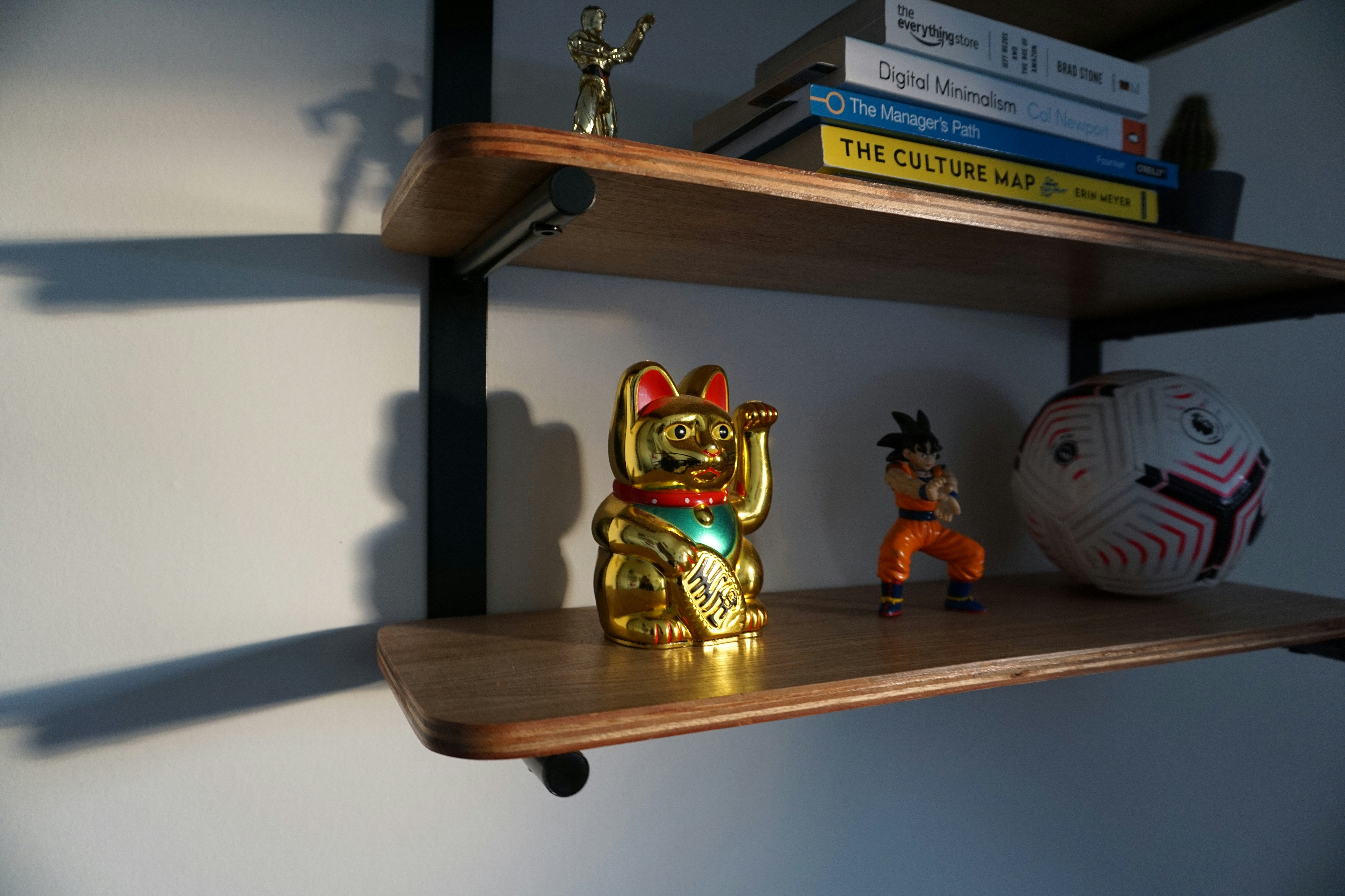 Minimalist wooden shelves holding decorative items and action figures.