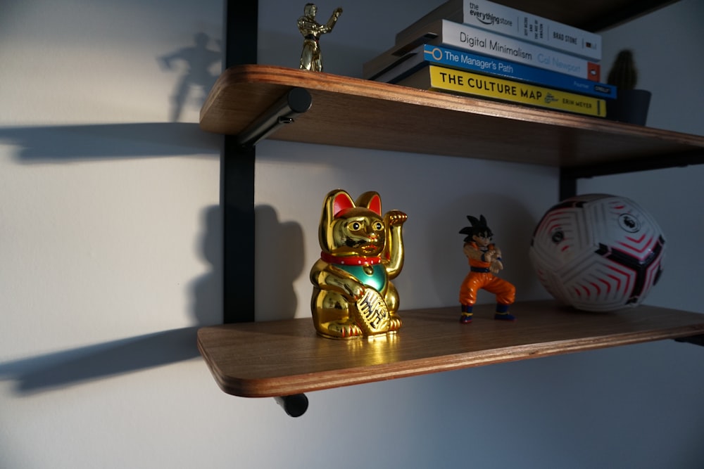 a shelf with some books and figurines on it