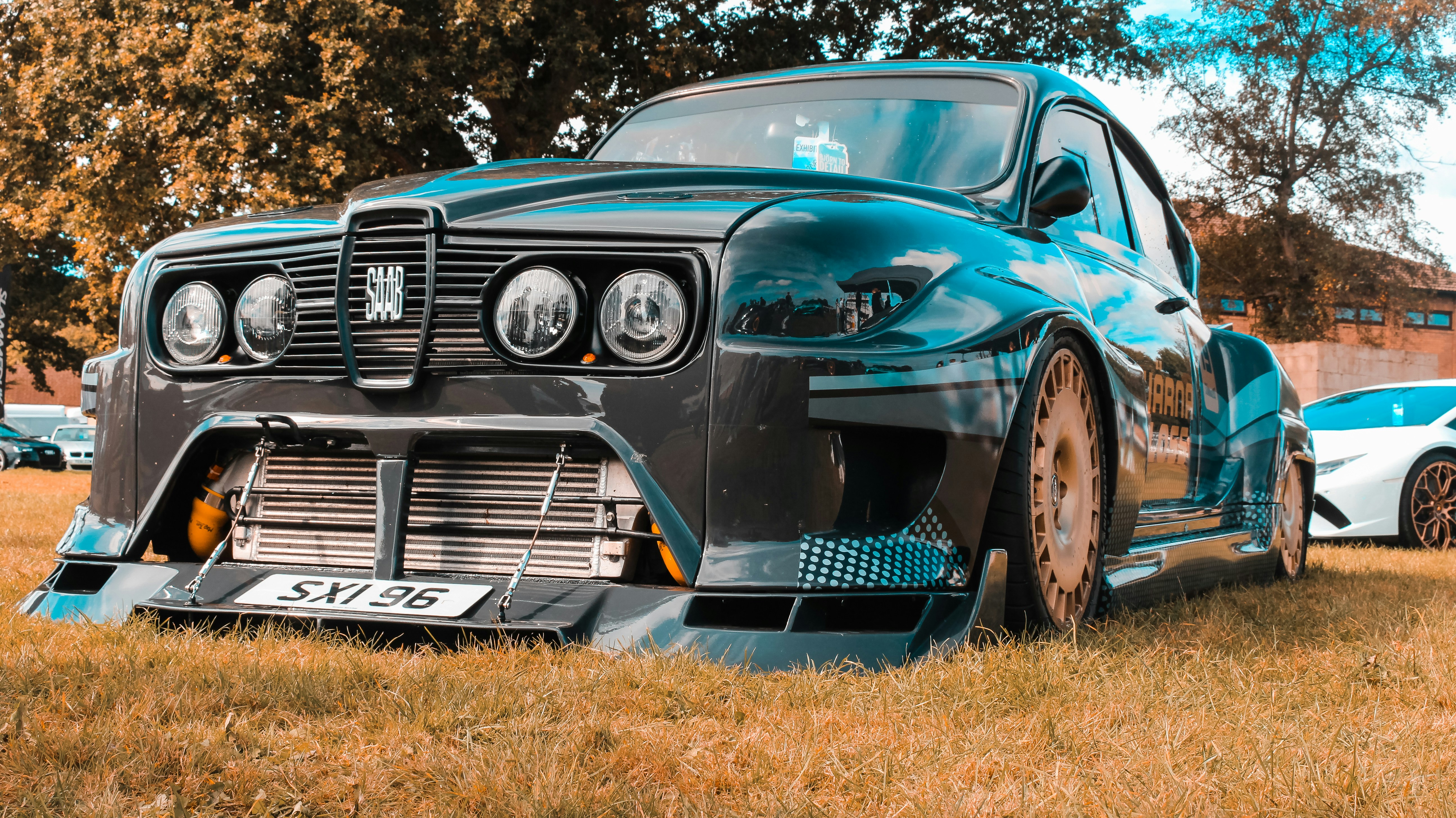 a blue and black car parked in a field