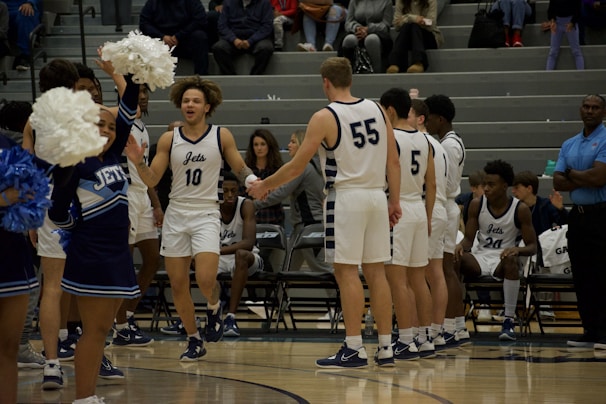 Dynamic shot of a high school basketball team celebrating a win in matching Apace Athletics uniforms.