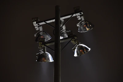 Outdoor LED floodlights casting a strong, clear light over a garden at night.