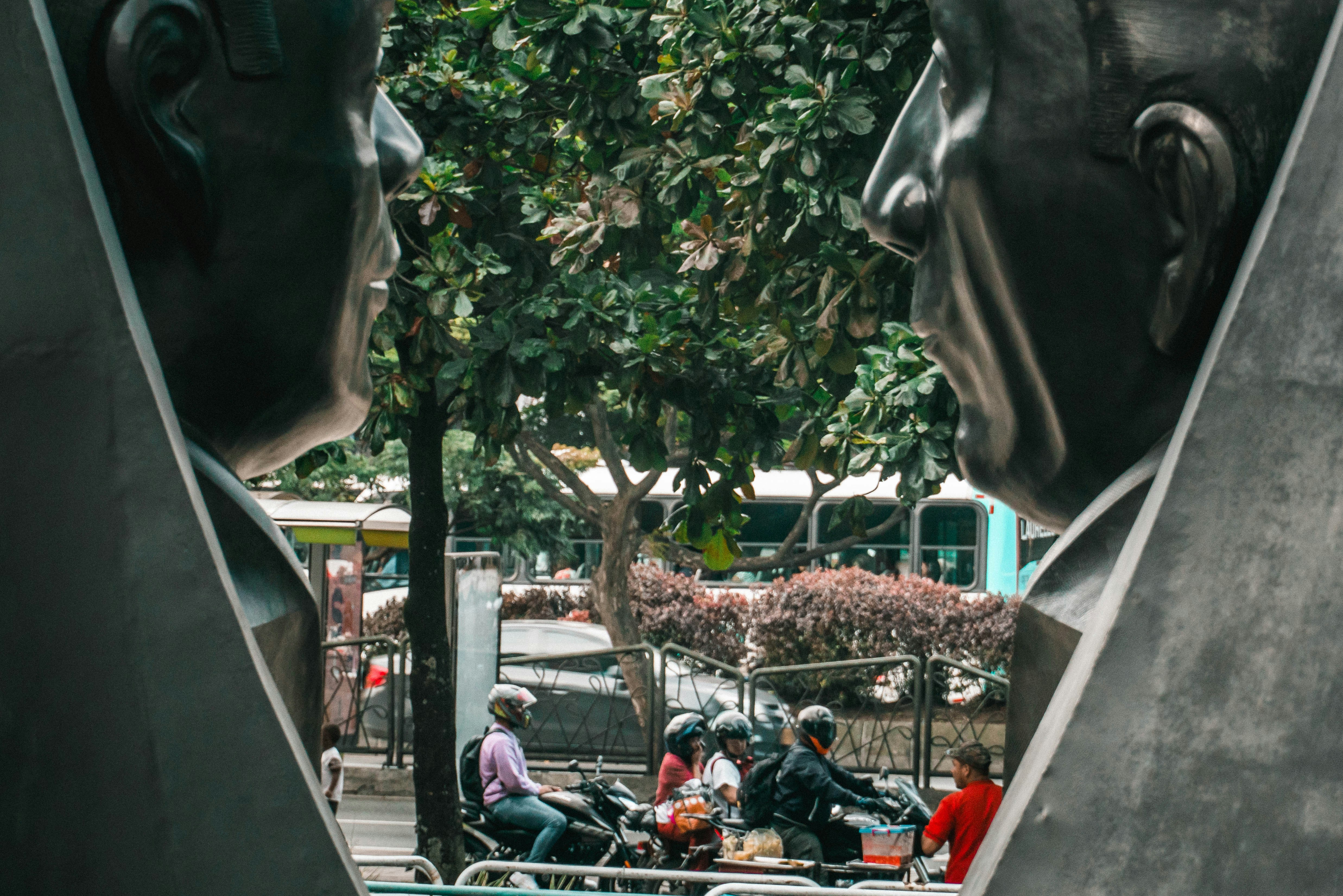 a group of people sitting on a bench next to a statue