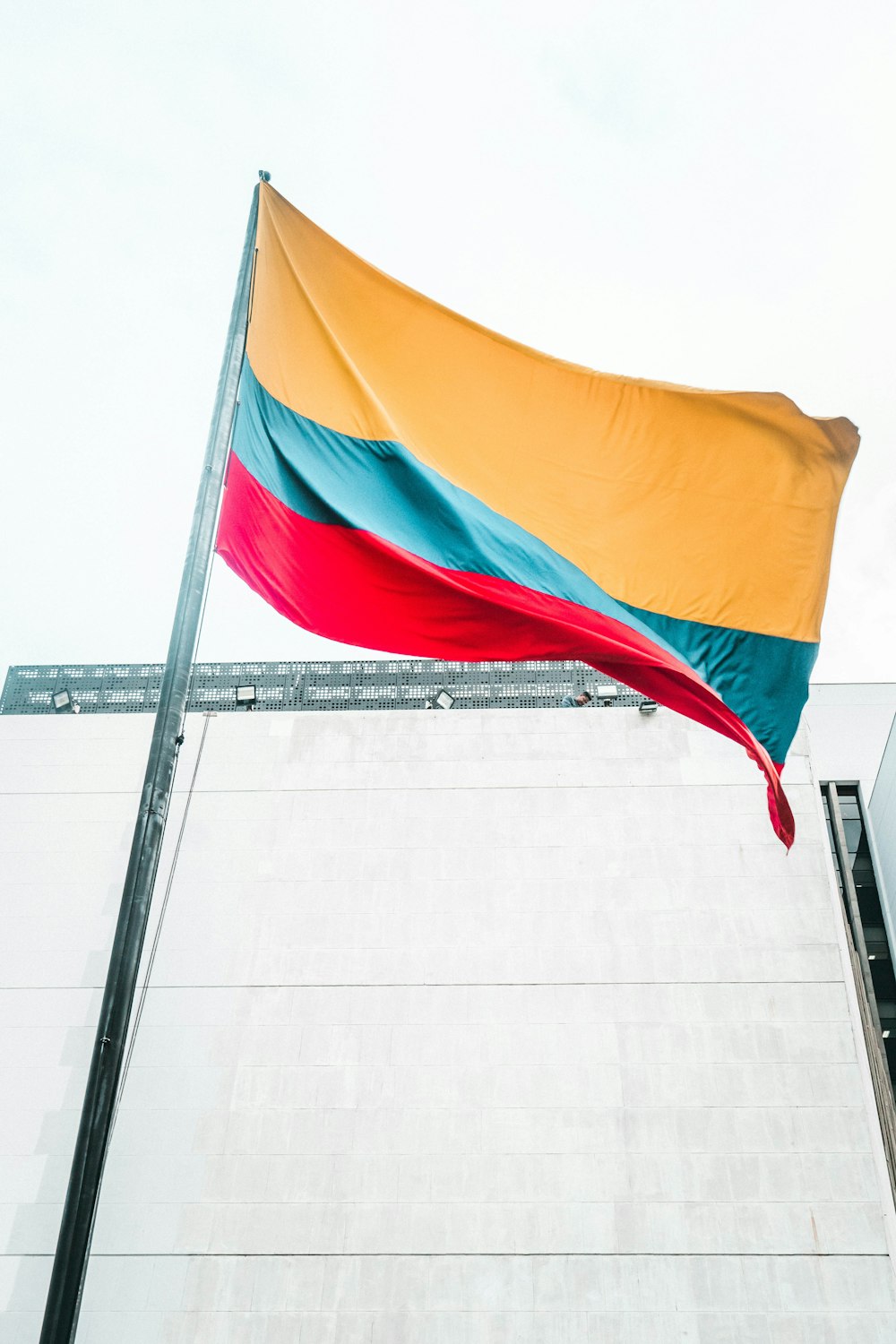 a large rainbow colored flag on top of a building