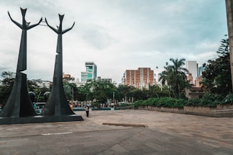 a couple of statues sitting on top of a cement ground