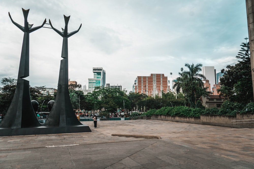 a couple of statues sitting on top of a cement ground