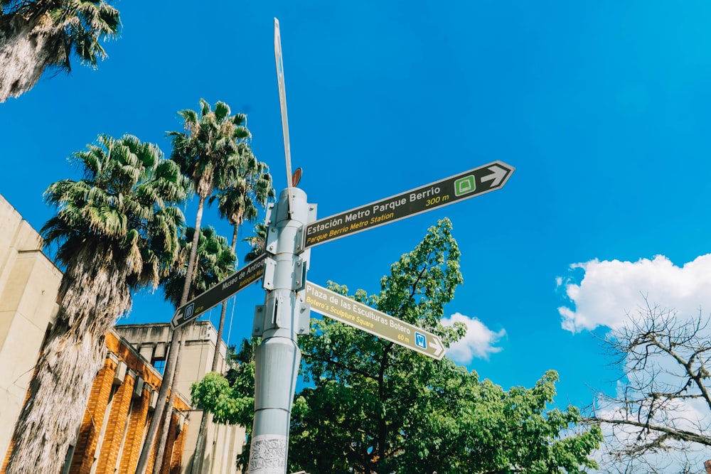 a street sign in front of a building with palm trees