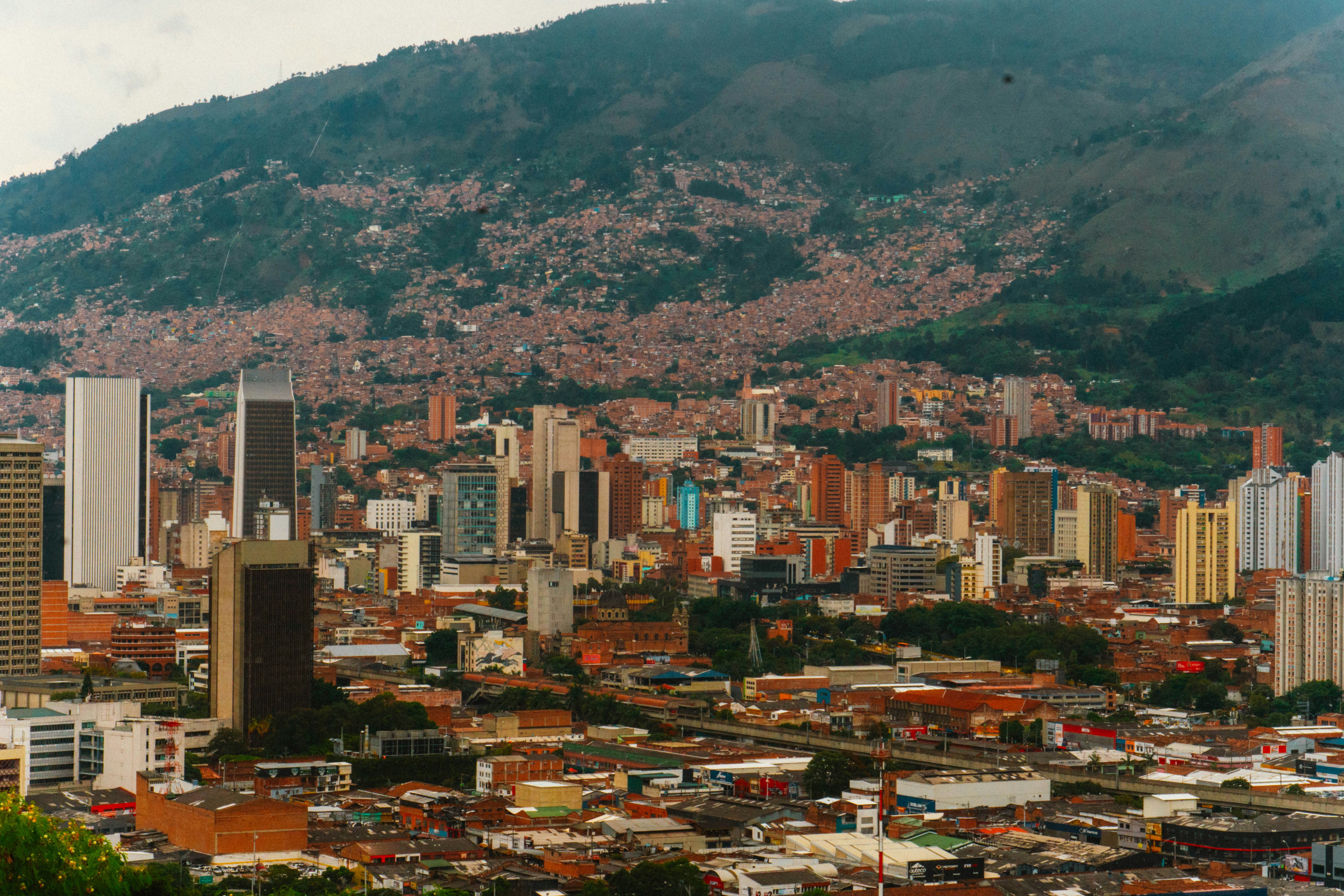 a view of a city with mountains in the background, 