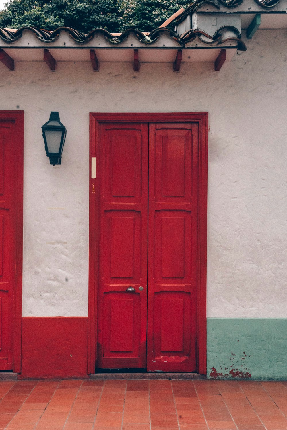 um par de portas vermelhas sentadas ao lado de um edifício
