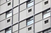 Close-up of wall cladding installation on a commercial building exterior.