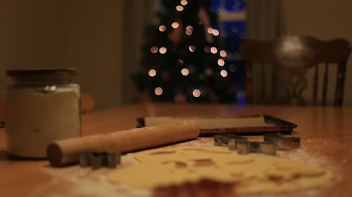 A cozy kitchen scene with freshly baked cupcakes and cookies arranged invitingly on a wooden table.