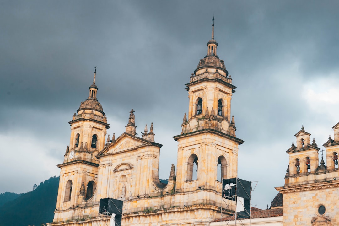 a large building with two towers under a cloudy sky,