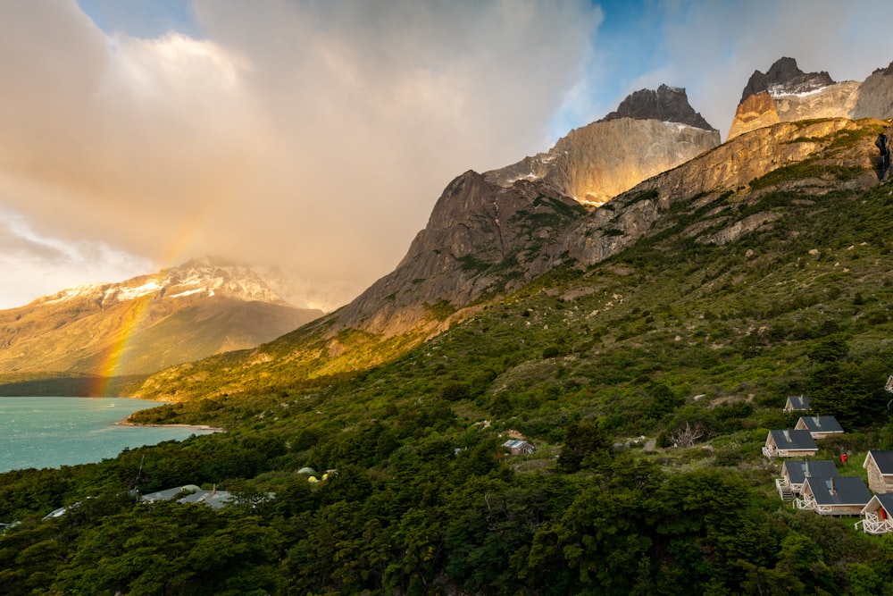 a rainbow shines in the sky over a mountain range