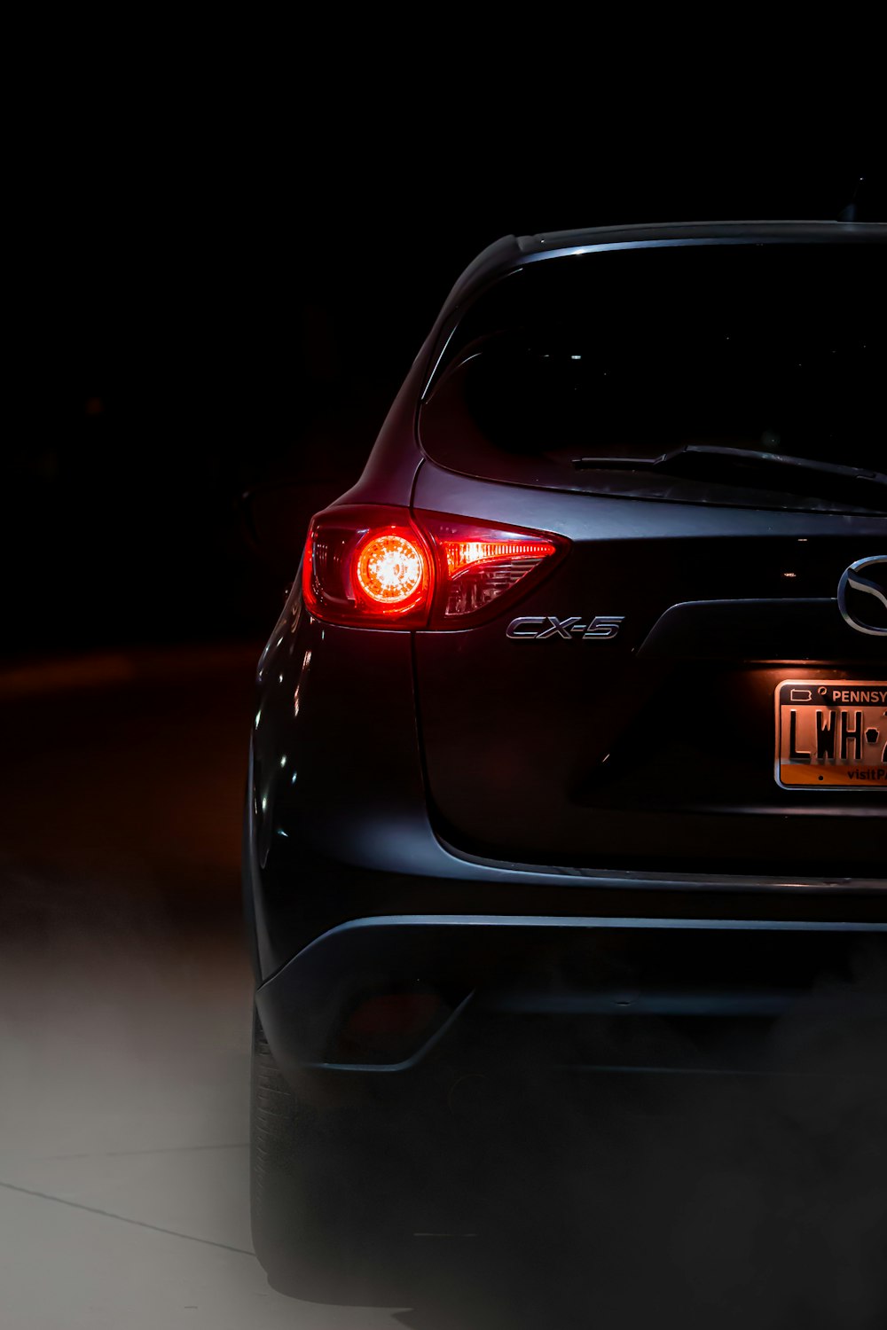 the back end of a black car in the dark