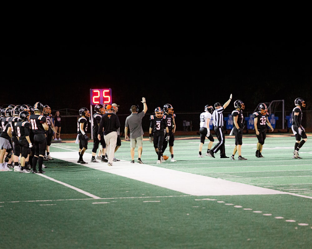 a group of football players standing on top of a field