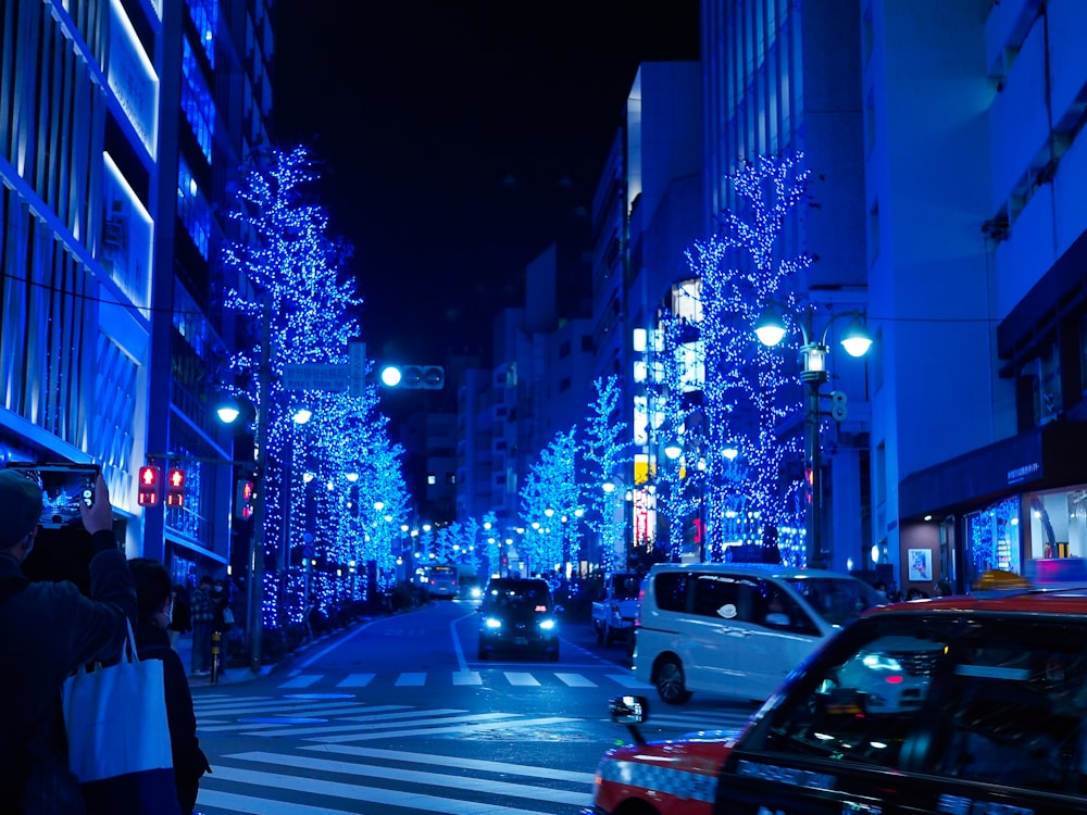 a city street at night with blue christmas lights