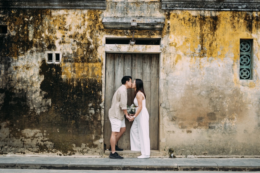a man and woman kissing in front of a door
