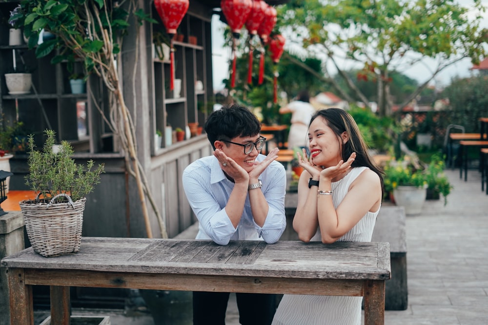 a man and a woman sitting at a wooden table